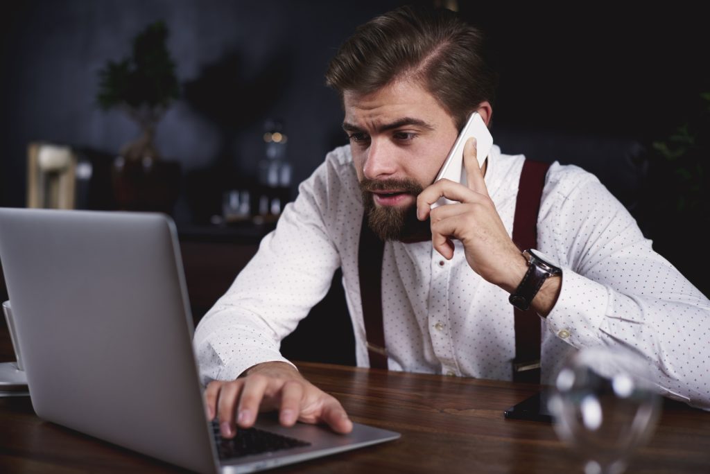 Embarrassed businessman working with technology